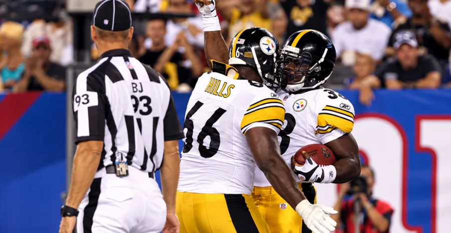 Tony Hills in a Steelers uniform celebrating with a teammate holding the football